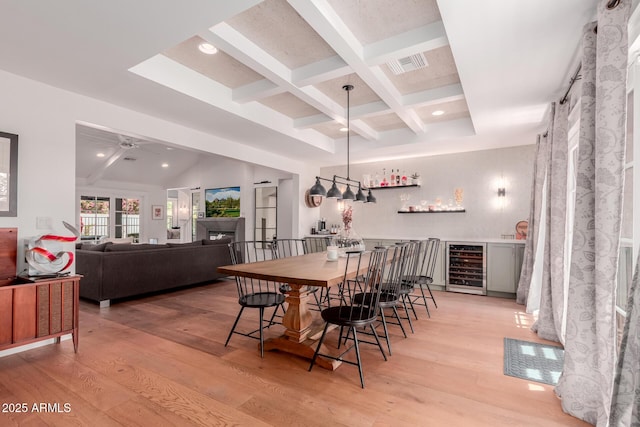 6196 E Calle Camelia, Scottsdale, AZ 85251 - dining space with wine cooler, beamed ceiling, coffered ceiling, light wood finished floors, and a dry bar