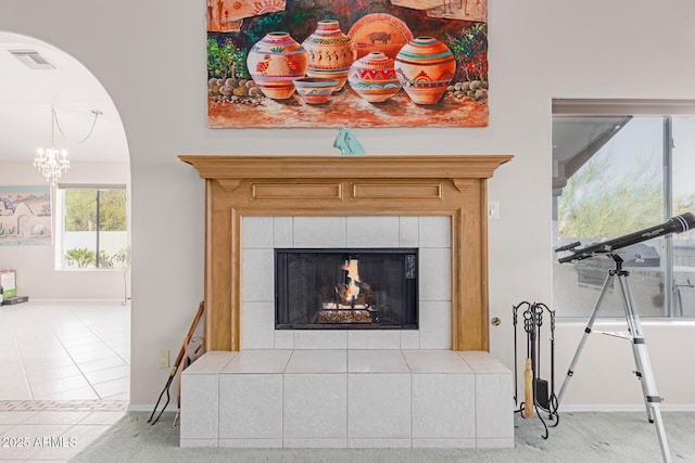 room details with a tile fireplace and a notable chandelier