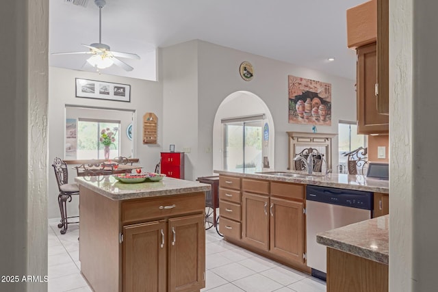 kitchen with light tile patterned flooring, dishwasher, sink, and a kitchen island