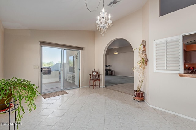 foyer entrance with an inviting chandelier, light tile patterned floors, and high vaulted ceiling