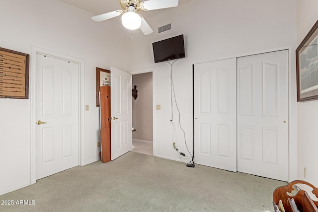 unfurnished bedroom with light carpet, a closet, and ceiling fan