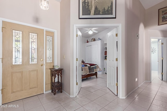 entrance foyer with light tile patterned flooring and high vaulted ceiling