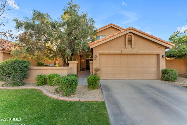 view of front of house with driveway, a garage, a tiled roof, fence, and stucco siding