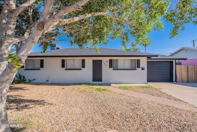 single story home with a garage, brick siding, fence, concrete driveway, and a shingled roof