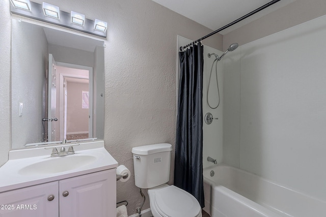 full bath with vanity, a textured wall, shower / bath combo, and toilet