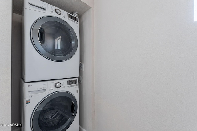 washroom with stacked washer / drying machine and laundry area
