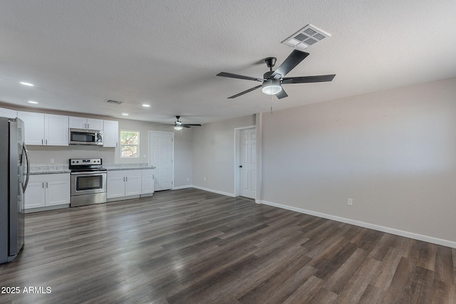interior space featuring ceiling fan, visible vents, dark wood-style floors, and baseboards