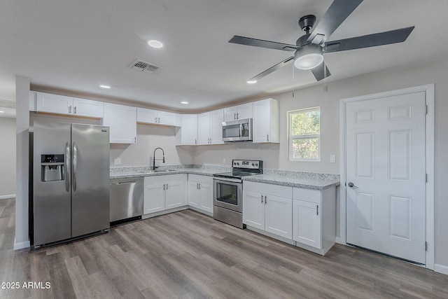 kitchen with white cabinets, appliances with stainless steel finishes, a sink, a ceiling fan, and visible vents