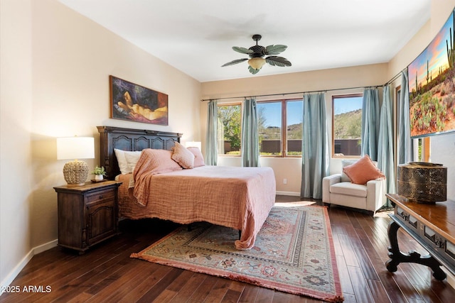 bedroom with ceiling fan, dark wood-type flooring, multiple windows, and baseboards