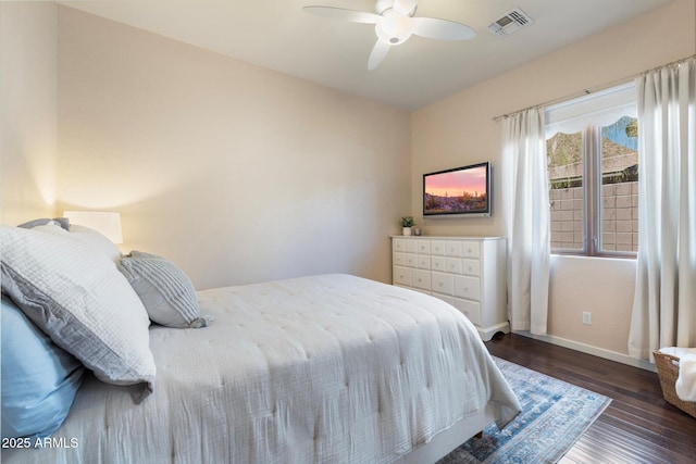 bedroom with ceiling fan, wood finished floors, visible vents, and baseboards