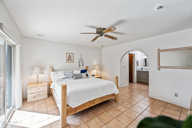 14830 N 28th Pl, Phoenix, AZ 85032 - bedroom featuring arched walkways, light tile patterned floors, a ceiling fan, and ensuite bath