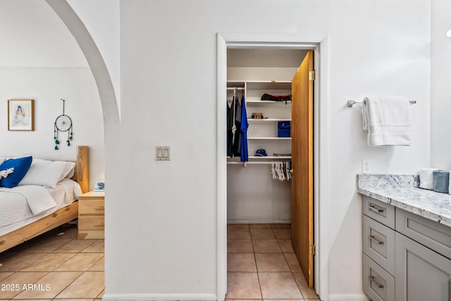 14830 N 28th Pl, Phoenix, AZ 85032 - bedroom featuring arched walkways, light tile patterned floors, a walk in closet, and a closet