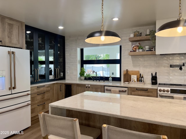 5556 E Sandra Ter, Scottsdale, AZ 85254 - kitchen with appliances with stainless steel finishes, backsplash, light stone counters, hanging light fixtures, and recessed lighting