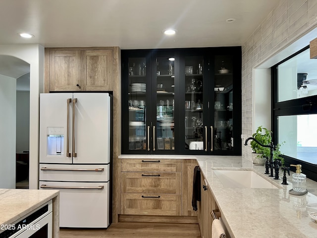 5556 E Sandra Ter, Scottsdale, AZ 85254 - bar area with high end white fridge, light wood-style floors, arched walkways, and recessed lighting