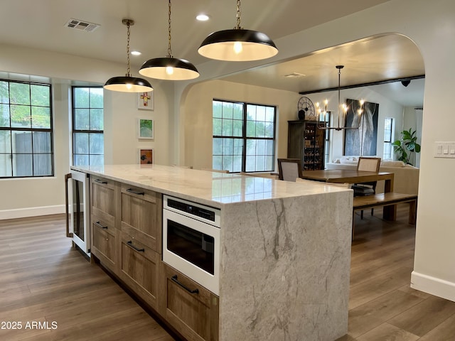 5556 E Sandra Ter, Scottsdale, AZ 85254 - kitchen with wine cooler, dark wood-style flooring, plenty of natural light, light stone countertops, and recessed lighting