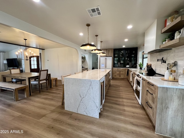 5556 E Sandra Ter, Scottsdale, AZ 85254 - kitchen featuring white fridge with ice dispenser, recessed lighting, light wood-type flooring, backsplash, and light stone countertops