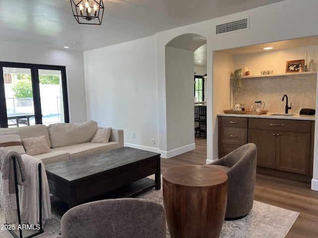5556 E Sandra Ter, Scottsdale, AZ 85254 - living room with wood finished floors, arched walkways, bar with sink, recessed lighting, and a chandelier