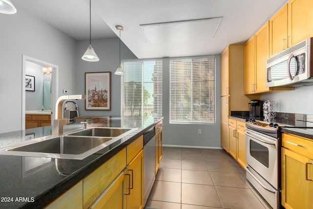 kitchen with appliances with stainless steel finishes, sink, light tile patterned flooring, and pendant lighting