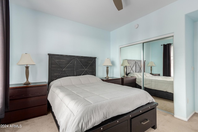 bedroom with light colored carpet, ceiling fan, and a closet