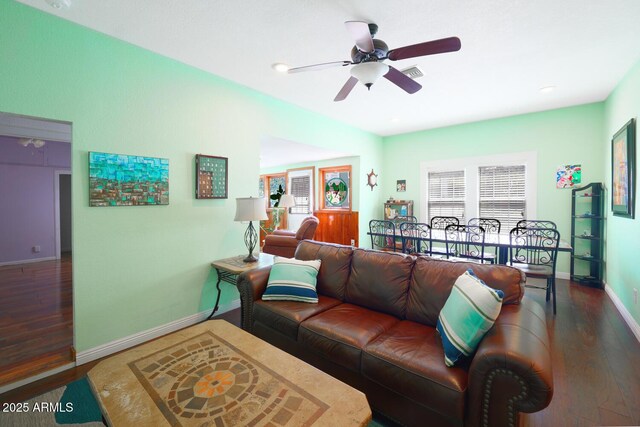 living room featuring ceiling fan and dark hardwood / wood-style floors