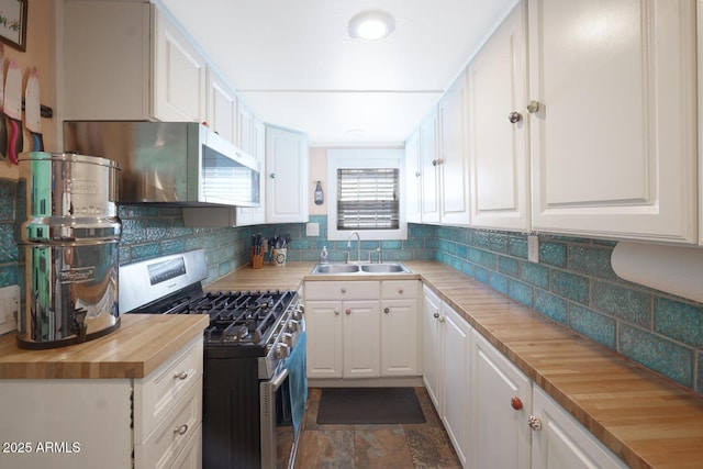 kitchen featuring stainless steel range with gas cooktop, wood counters, white cabinetry, sink, and decorative backsplash
