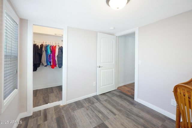 bedroom featuring dark hardwood / wood-style flooring, a spacious closet, and a closet