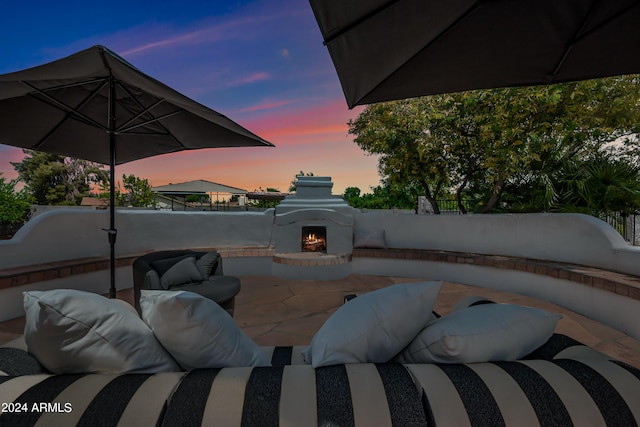 patio terrace at dusk with exterior fireplace