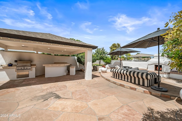 view of patio with area for grilling, an outdoor living space, and exterior kitchen