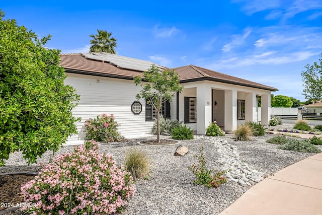 ranch-style house featuring solar panels and a porch