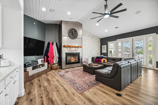 living room with a fireplace, light hardwood / wood-style flooring, ceiling fan, and wood ceiling