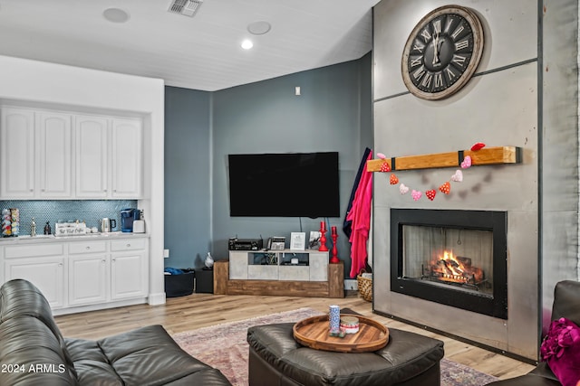 living room featuring light wood-type flooring and sink