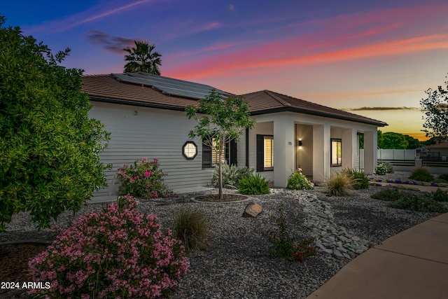 view of front of property with covered porch and solar panels