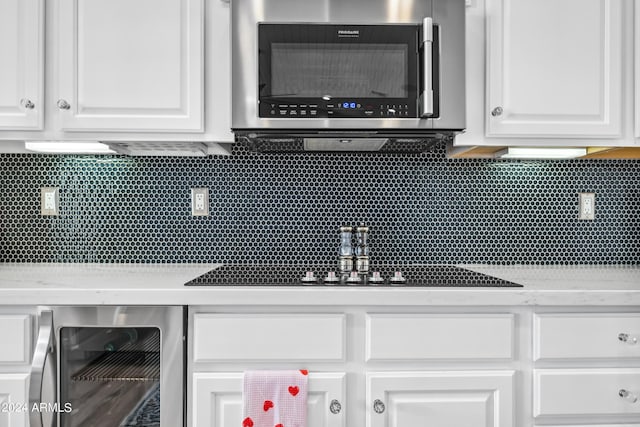 kitchen featuring white cabinets, light stone countertops, tasteful backsplash, and beverage cooler