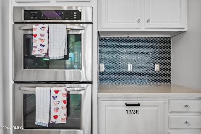 kitchen with double oven, backsplash, and white cabinets