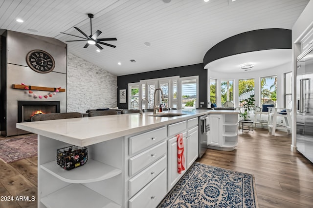 kitchen with white cabinets, light stone counters, wooden ceiling, and a kitchen island with sink