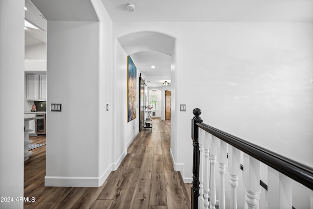 corridor featuring lofted ceiling, wine cooler, and dark wood-type flooring