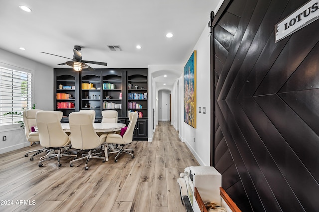 dining area with ceiling fan, light wood-type flooring, and built in features