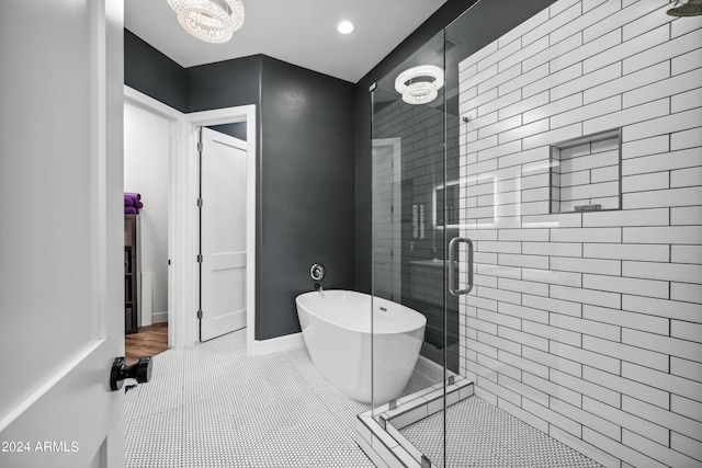 bathroom with tile patterned flooring, independent shower and bath, and an inviting chandelier