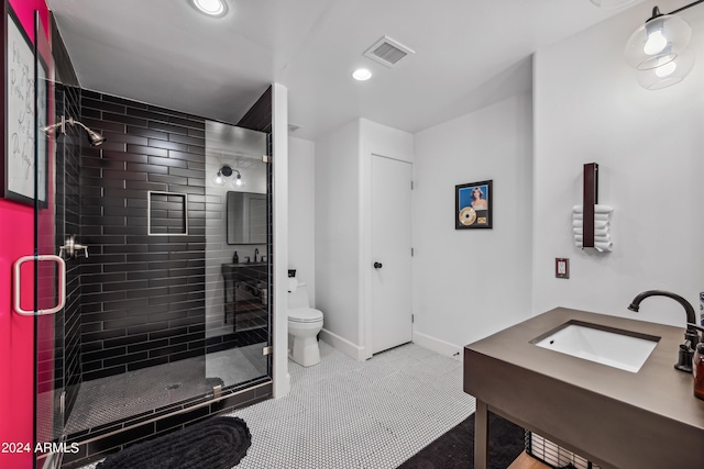 bathroom featuring an enclosed shower, vanity, toilet, and tile patterned floors