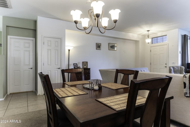 tiled dining area featuring an inviting chandelier