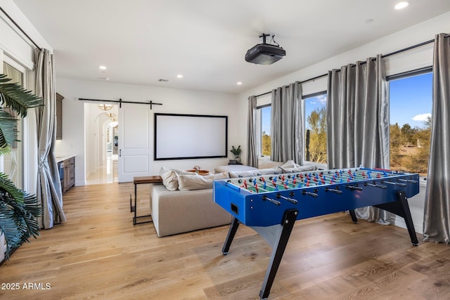 recreation room featuring light hardwood / wood-style flooring and a barn door