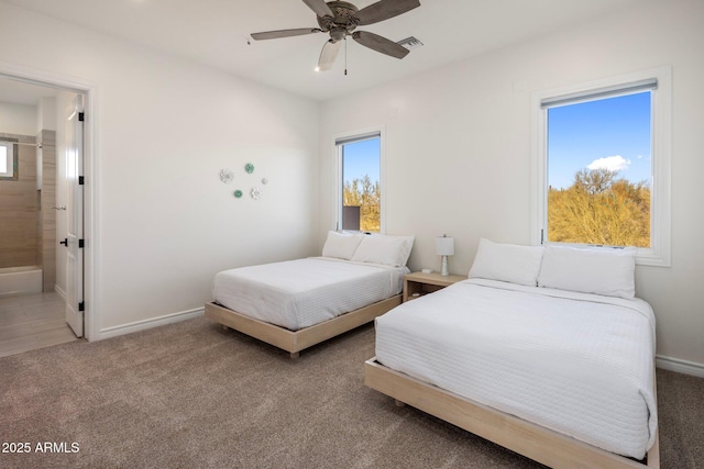 carpeted bedroom with ceiling fan and ensuite bath