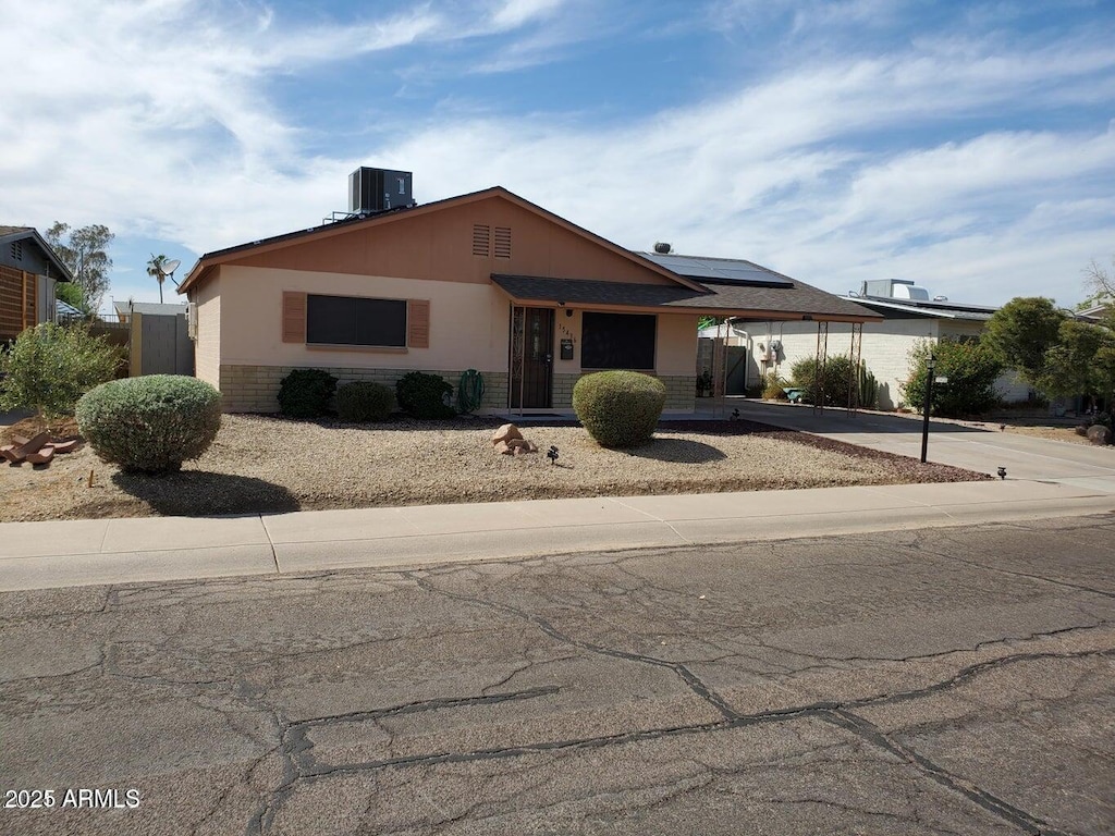 view of front of home featuring cooling unit and solar panels