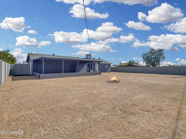 back of house featuring a fire pit, cooling unit, a fenced backyard, and a sunroom