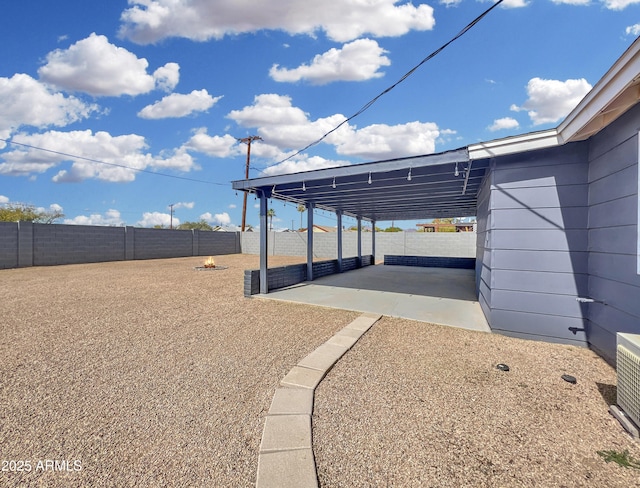 view of yard featuring a patio area, a fenced backyard, and an attached carport