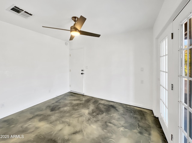 spare room with concrete flooring, visible vents, and a ceiling fan