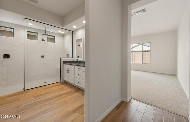 bathroom featuring a tile shower and vanity