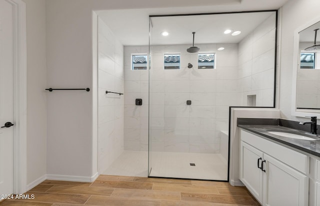 bathroom featuring plenty of natural light, a tile shower, and vanity