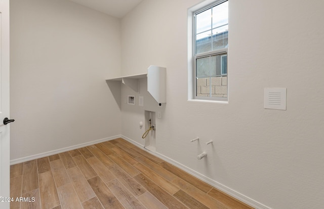 laundry area featuring hookup for a gas dryer, light hardwood / wood-style floors, and washer hookup