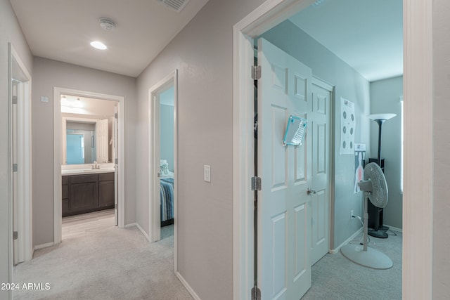 hallway featuring light colored carpet